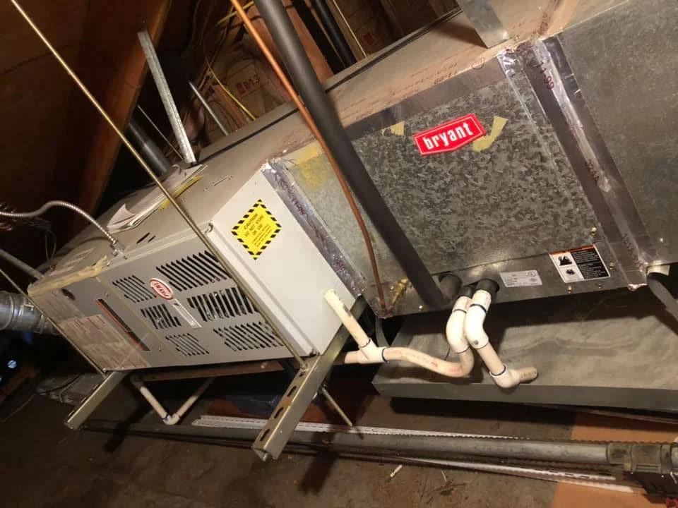 Bryant AC condenser unit with air handler and refrigerant lines installed on concrete pad