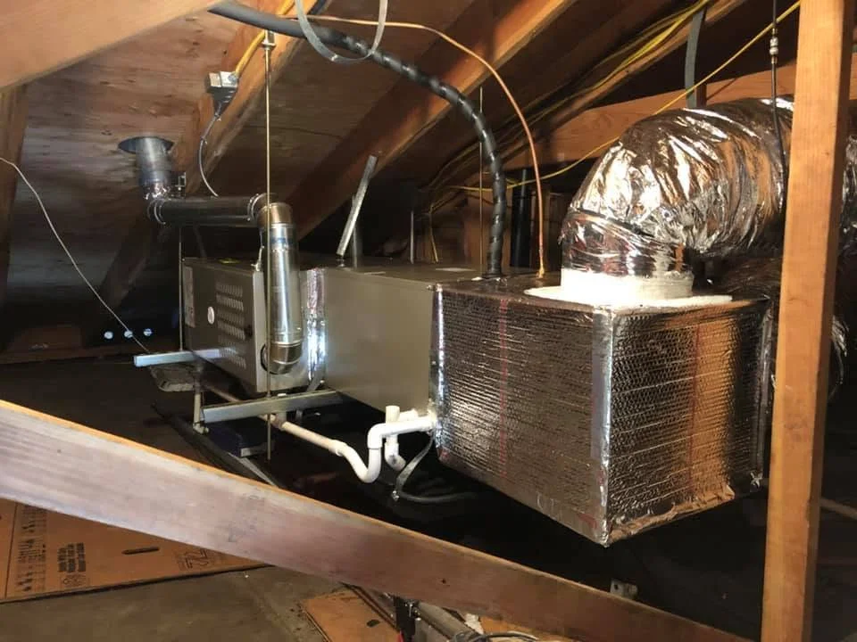 Attic furnace installation with insulated ductwork, metal piping, and flexible connectors